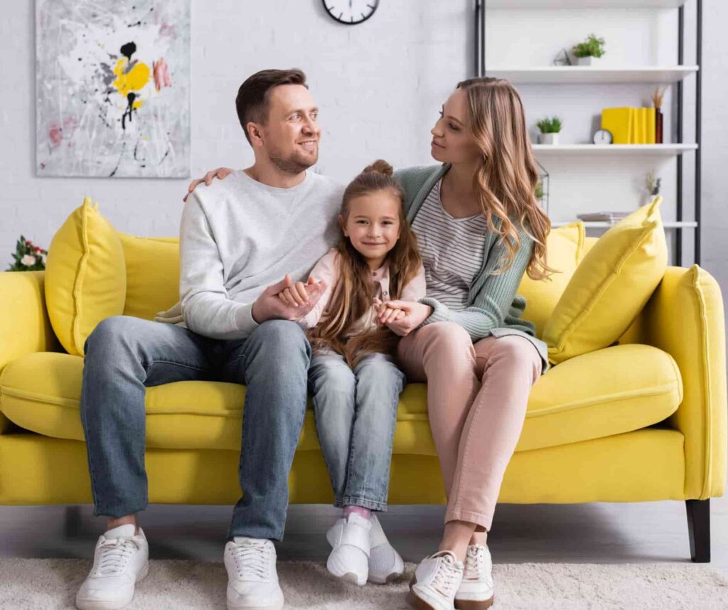 Tata i mama siedzą z córką na kanapie