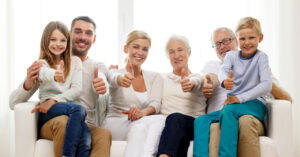 Uśmiechnięci rodzice, dzieci i dziadkowie siedzą na kanpie