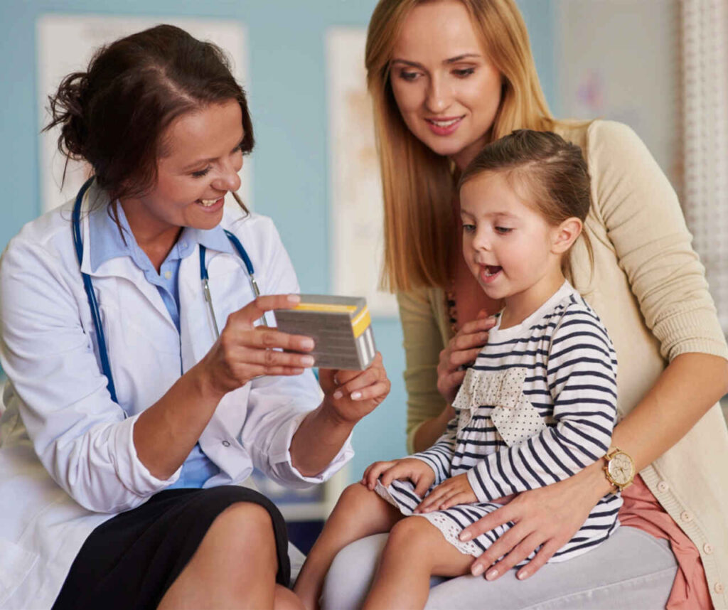 Lekarz, kobieta i dzieckoa oglądaja pudełko