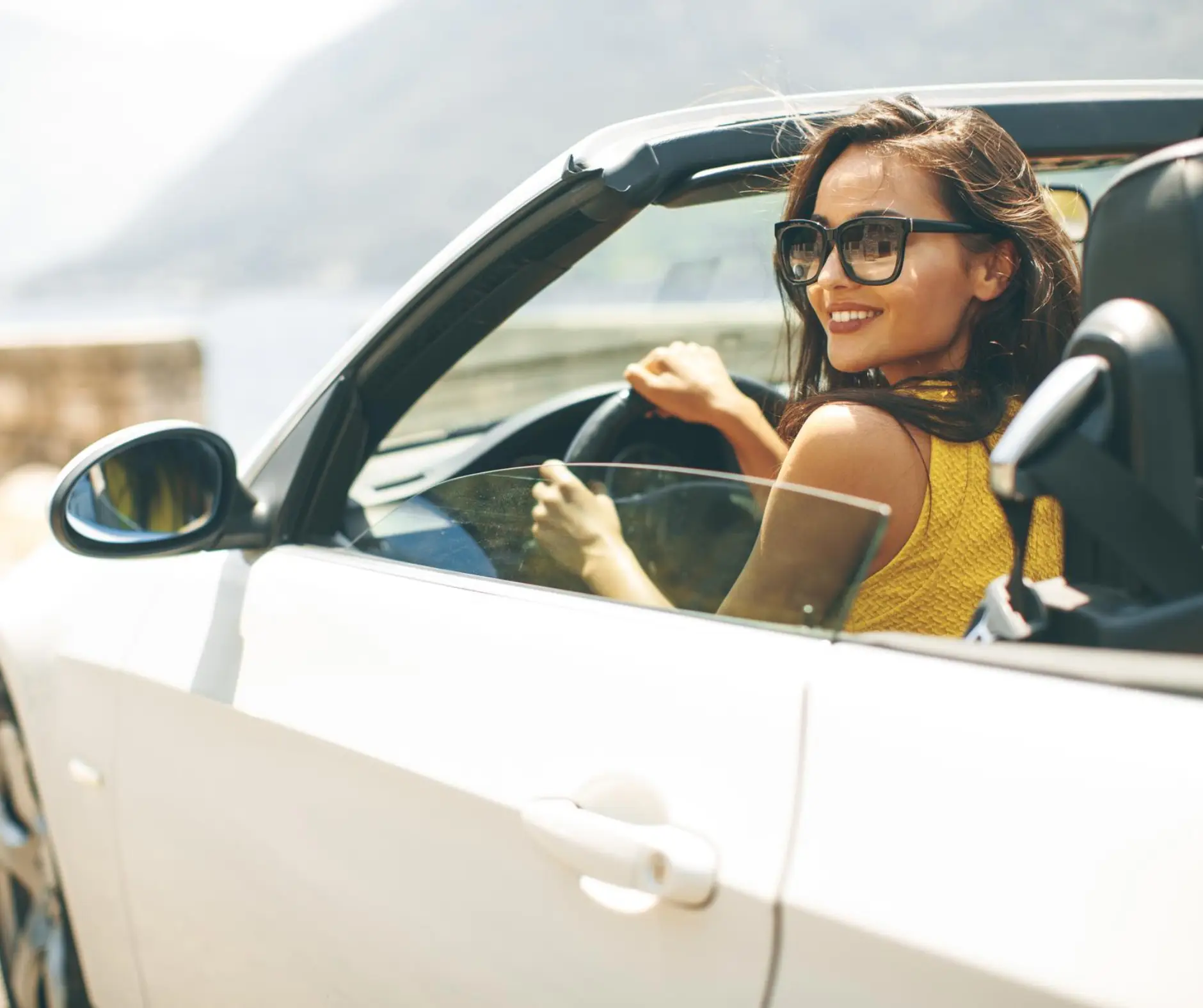 Uśmiechnięta kobieta w kabriolecie