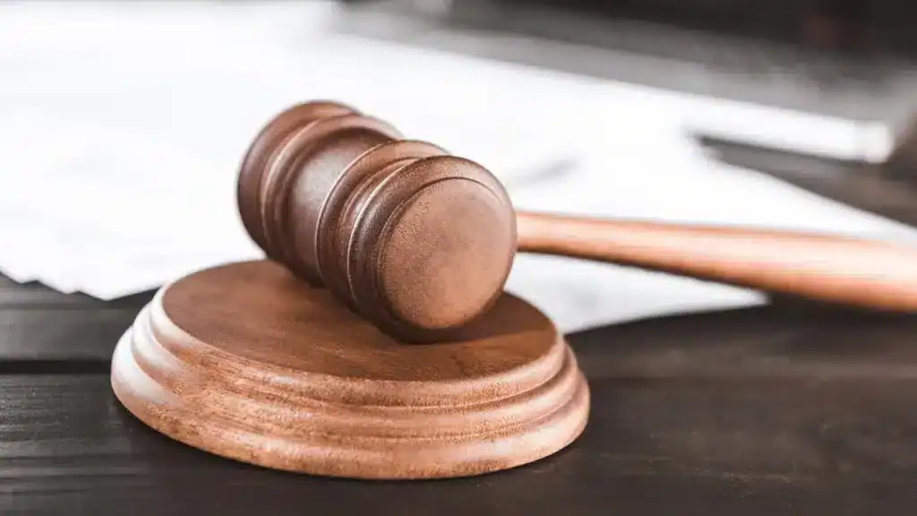 TARCZA Ubezpieczenie Odpowiedzialności Cywilnej - Młotek sędziowski na biurku.